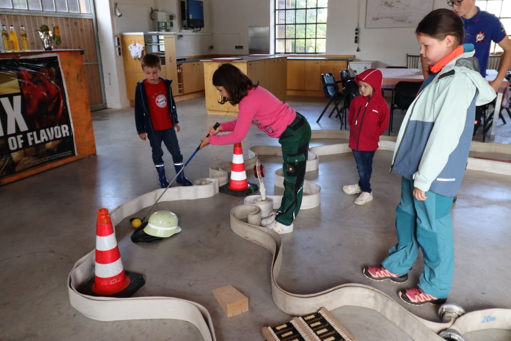 Minigolf mit Hilfe von Feuerwehrausrüstung