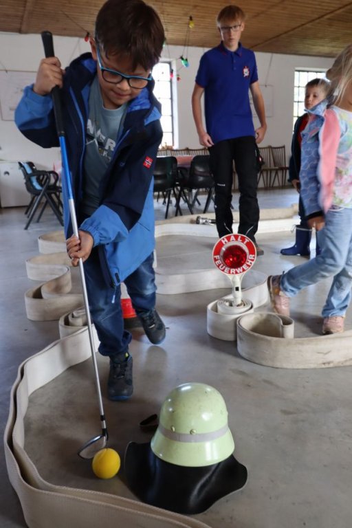 Minigolf mit Hilfe von Feuerwehrausrüstung