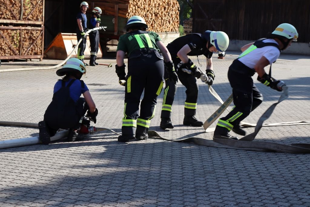 Wassertrupp kuppelt C-Leitung, Schlauchtrupp unterstütz beim Schlauch verlegen