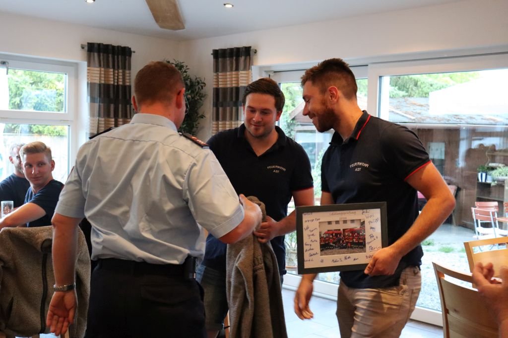 Mannschaft überrascht den Kommandanten mit einer Trachtenjacke und einem Gruppenfoto